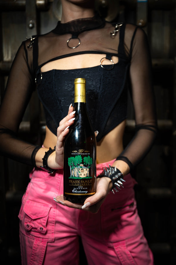 Model holding bottle of Frank Family Chardonay. Image is promoting our new blog with fun content you can pull up a chair and have a glass of wine to read.