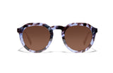 Image of Cheeterz Club eyewear. Photo of round sunglasses with brown tinted lenses. The frames are medium width with glitter infused blue and black color and spotted print, suitable for square, oval, and oblong face shapes. 