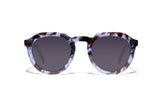 Image of Cheeterz Club eyewear. Photo of round sunglasses with gray tinted lenses. The frames are medium width with glitter infused blue and black color and spotted print, suitable for square, oval, and oblong face shapes. 