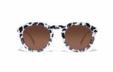 Image of Cheeterz Club eyewear. Photo of round sunglasses with brown tinted lenses. The frames are medium width with white and black color and cheetah print, suitable for square, oval, and oblong face shapes. 