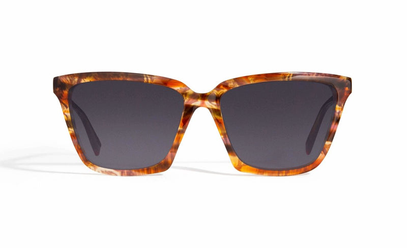 Image of Cheeterz Club eyewear. Photo of cat eye sunglasses with gray tinted lenses. The frames are medium width and golden brown color with honey and dark brown accents. Suitable for round, oval, and heart shaped face shapes. 